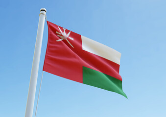 The national flag of Oman waving on a pole under a bright blue sky. A patriotic representation of Omani pride, independence, and unity, perfect for editorial and cultural stock use
