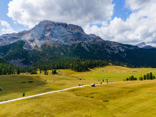 Naklejka premium Beautiful landscape in Dolomites, Italy. Malga Prato Piazza meadow and big mountain summit and ridge. South Tyrol region in Italy. Trekking and bike road in Italy Dolomites. Wooden cabin hut.