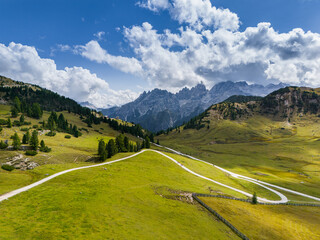 Beautiful landscape in Dolomites, Italy.  Malga Prato Piazza meadow and big mountain summit and ridge. South Tyrol region in Italy. Trekking and bike road in Italy Dolomites. Wooden cabin hut.