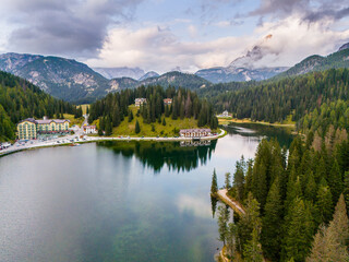 Aerial view of breathtaking landscape of Lake Misurina and hotel. Dolomites mountain in background, IAlpine lake in the Italian Alps. Drone view of Lago di Misurina. Mountain forest lake with a view.