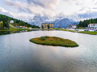Aerial view of breathtaking landscape of Lake Misurina and hotel. Dolomites mountain in background, IAlpine lake in the Italian Alps. Drone view of Lago di Misurina. Mountain forest lake with a view.