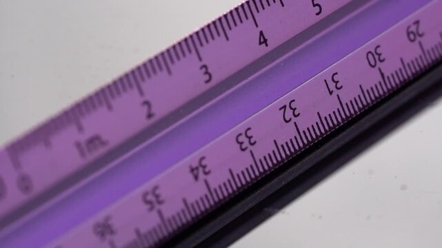 Macro shot of metallic measuring ruler on desk with blurred background, static composition.