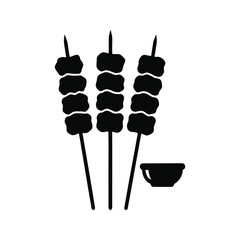 Three skewers with food, next to a small bowl.