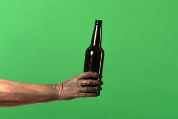 Naklejka premium A creepy zombie hand holds a beer bottle