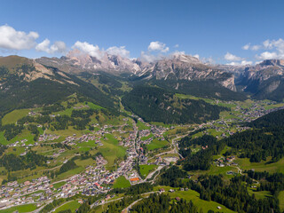 Val Gardena Village Nested Down The Valley Surrounded By The Dolomite Mountain Ranges In South Tyrol, Italy. Aerial Shot. Ortisei in Val Gardena filmed by drone, dense forests and mountain peaks. 