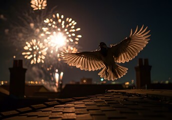 A bird in silhouette with wings spread wide flies in front of a vibrant display of fireworks exploding in the night sky over a city skyline with rooftops and chimneys visible