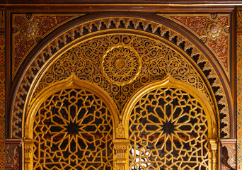 Golden archway featuring geometric lattice panels, ornate arabesque motifs