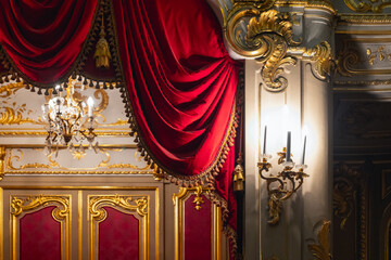 Opulent Baroque-style interior featuring red velvet drapes, gilded panels
