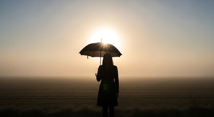 Silhouette of woman holding umbrella against bright sunlit background