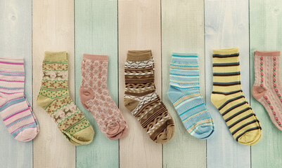 Colorful socks on a multicolored striped background. A panorama of socks for the cold seasons.