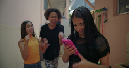 Teenager reacting regretfully to embarrassing viral video reveal while friends laugh and mock her in suburban alleyway, exploring peer pressure and digital media culture