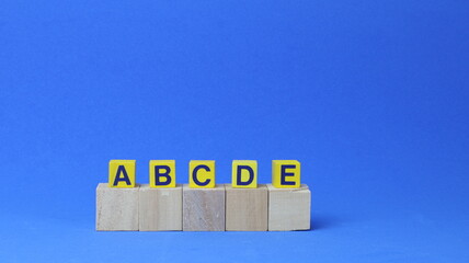Due file di cubi di legno con le lettere A, B, C, D ed E. Concetto di priorit&agrave; e gestione delle attivit&agrave;. Assegnazione delle priorit&agrave; a qualsiasi attivit&agrave;.