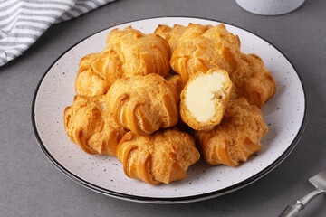Cakes profiteroles arranged on a plate ready for enjoyment during a cozy afternoon