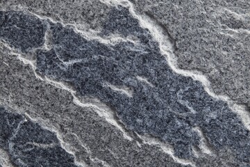 Naklejka premium Macro close-up of a layered stone surface, showcasing a mix of gray and blue-gray hues