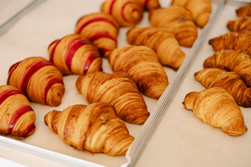 Appetizing freshly baked berry raspberry croissants in the bakery window.