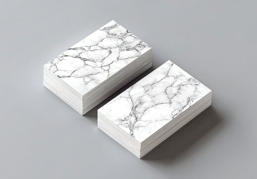 Two stacks of rectangular cards. White edges are stacked on a neutral gray surface. Cards have a marbled texture