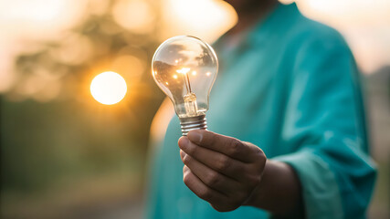 Hand presenting warm bulb with person blurred