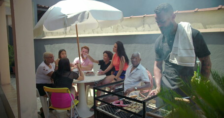 Group of diverse friends and family raising glasses in toast at outdoor barbecue, celebrating unity...