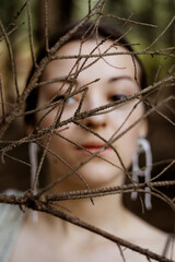 Thoughtful young woman face closeup in forest background.