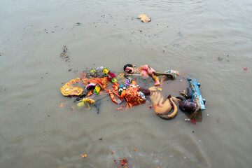 Hindu devotees immerse a clay idol of Goddess Durga into the Brahmaputra River on the concluding day of the Durga Puja festival