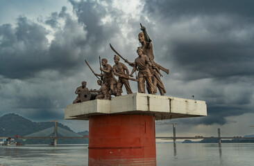 A statue of Lachit Borphukan stands in the Brahmaputra River under a cloudy sky