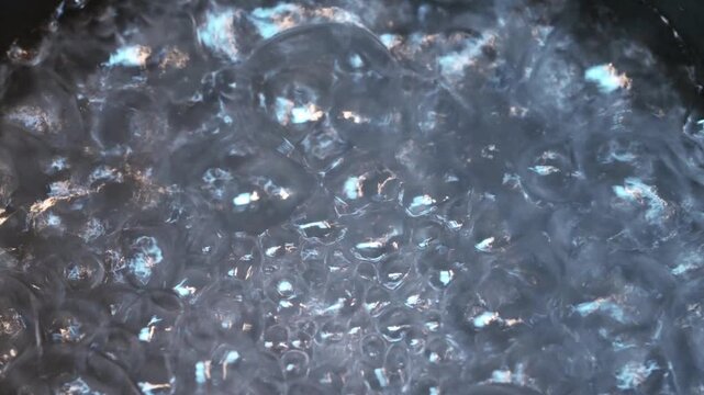 Close-up of water boiling with rising bubbles