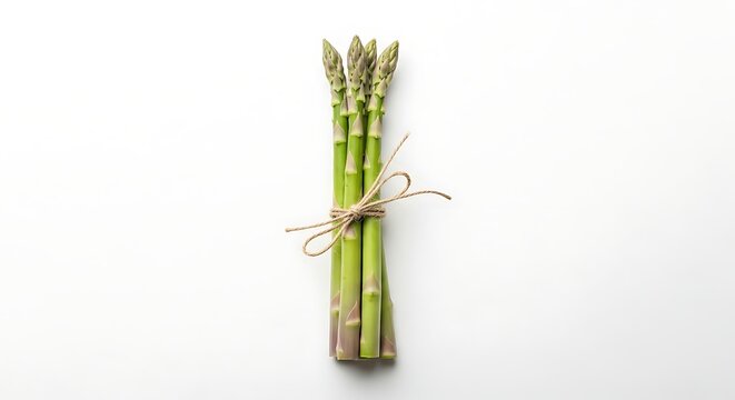 A bunch of fresh green asparagus tied with twine on a white background in a studio setting view from above