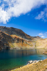 A scenic view of the mountain's lake which is surrounded by mountains and forest.