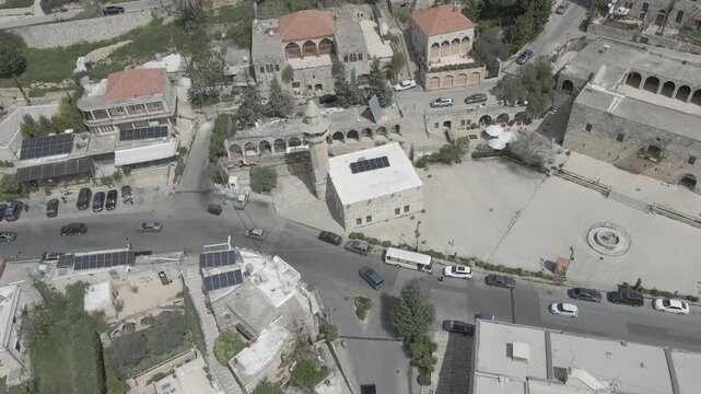 Aerial view of the historic main square in Deir el Qamar, Lebanon, surrounded by traditional stone buildings, houses, and cultural landmarks. 