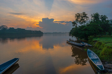 Amazon river rainforest sunrise with canoes, Cuyabeno wildlife reserve, Ecuador.