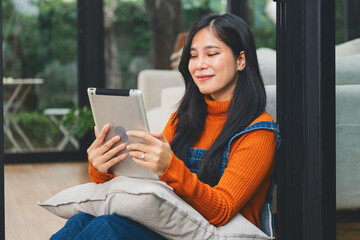 woman is sitting on  floor with  tablet in her hand