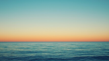 Vast expanse of tranquil ocean water under a colorful gradient sky at dusk or