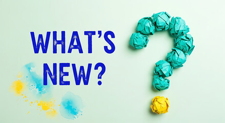 A question mark made of crumpled blue paper balls with a yellow ball at the end, asking whats new