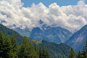 Clouds over mountains and valleys with forest in La Vanoise national park, Savoie, France 