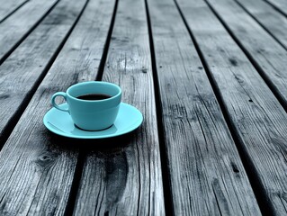 Aesthetic turquoise coffee cup and saucer on rustic gray wooden surface, artistic