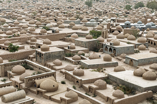View of countless sun-baked tombs stretch across the arid landscape, a silent city of rest under the vast sky, Kashgar Cemetery, Kashgar, Xinjiang, China.