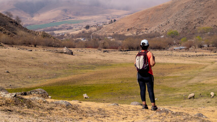 young woman hiking in a mountain area located in Tafi del Valle, Tucuman. in a spring warm morning