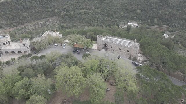 Aerial view of Moussa Castle, a famous historical landmark and museum located near Deir el Qamar, Lebanon, surrounded by forested mountains. 