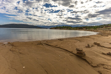 Scenic Mediterranean Landscape with Rocky Coastline, Green Bushes, and Dramatic Sky Rab Croatia