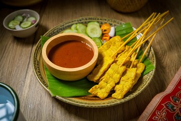 Pork Satay with Peanut Sauce and pickles which are cucumber slices and onions