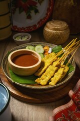 Pork Satay with Peanut Sauce and pickles which are cucumber slices and onions