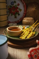 Pork Satay with Peanut Sauce and pickles which are cucumber slices and onions