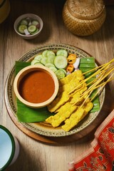 Pork Satay with Peanut Sauce and pickles which are cucumber slices and onions