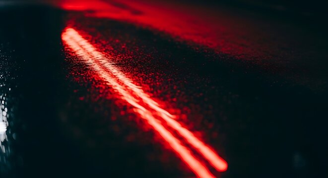 Vibrant Red Light Trails Reflecting on a Wet, Dark Surface at Night