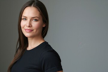 Obraz premium Woman with long hair wearing a black t-shirt and smiling, demonstrating the use of a back support belt for back pain relief and spinal alignment in a neutral background.