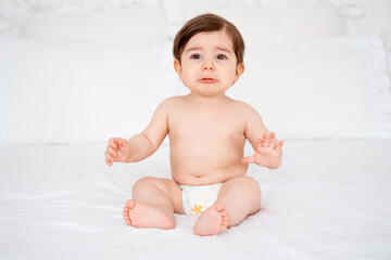A crying baby on a white bed at home, a place for text