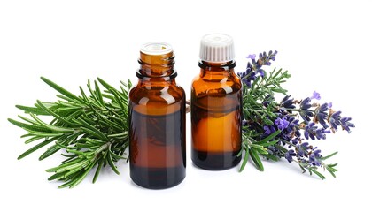 Two amber glass bottles of essential oil are surrounded by sprigs of rosemary, lavender, and other greenery, against a clean white backdrop