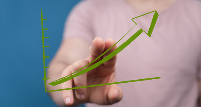 Stock photo of a hand interacting with a rising green graph, symbolizing growth, progress, and success.