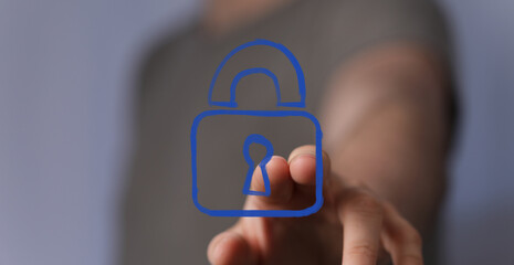 A hand interacting with a glowing blue virtual padlock icon, symbolizing digital security, data...