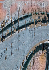 cracked and peeling paint on a wall surface. The weathered texture shows layers of faded blue and white paint flaking off, revealing an aged and distressed background. Perfect as a grunge overlay.